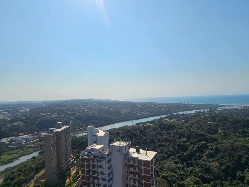 An elevated panoramic view overlooking the surrounding urban landscape, river, and distant coastline.