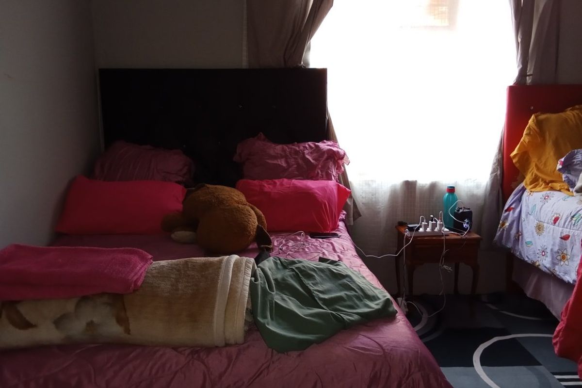 A bedroom featuring a window with curtains, providing natural light to the space.
