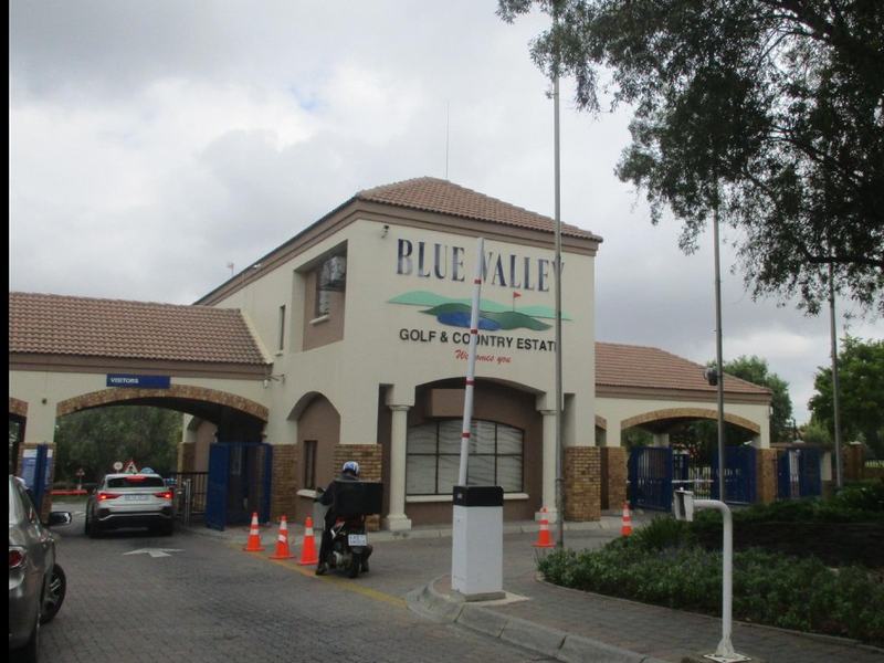The main entrance gatehouse of Blue Valley Golf & Country Estate, featuring a secure boom gate access point and brick architectural detailing.