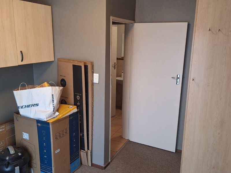 A functional hallway area featuring built-in cabinetry and storage cupboards, providing convenient access to adjacent rooms within the apartment.
