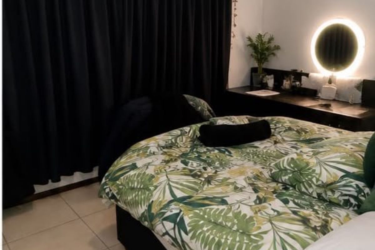 A bedroom featuring tiled flooring and a built-in vanity unit with integrated lighting.