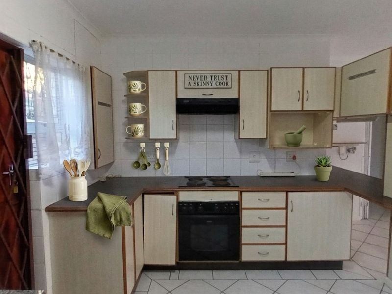 A functional kitchen featuring built-in cabinetry, laminate countertops, an electric hob, and an integrated oven with a tiled backsplash.