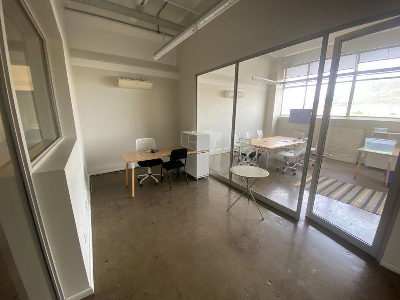 Modern commercial office space featuring polished concrete floors, glass partitioning, and large windows providing natural light and an open, professional atmosphere.
