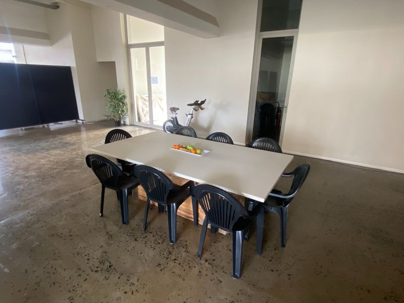 Spacious open-plan commercial area featuring polished concrete floors and large glass panel doors, offering a versatile layout for various business configurations.