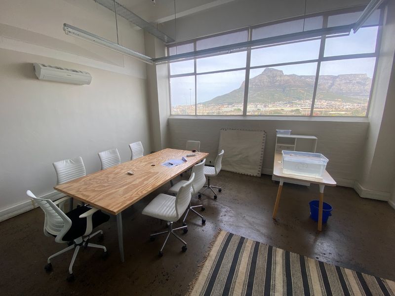 Spacious commercial office featuring large windows with mountain views, polished concrete floors, and an integrated air conditioning unit.