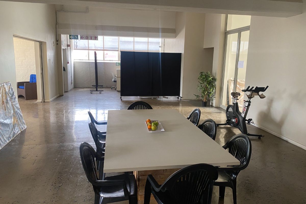 Spacious open-plan commercial area featuring polished concrete floors, exposed structural beams, and large industrial-style windows providing ample natural light.