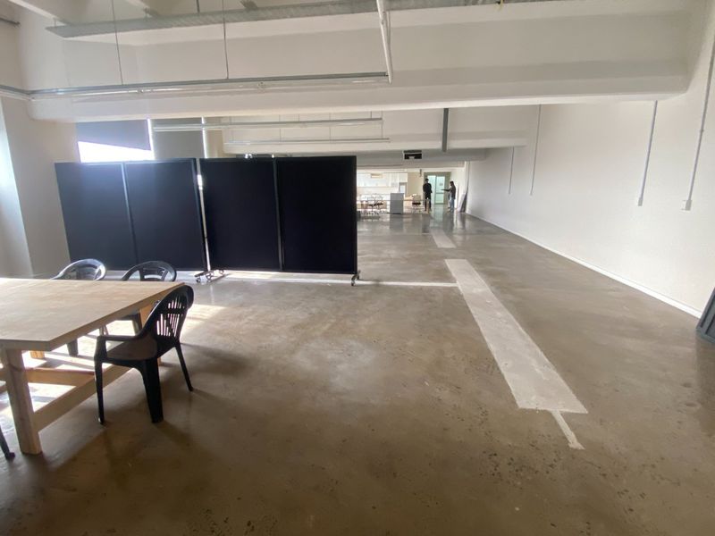 Spacious open-plan commercial office area featuring exposed concrete flooring and industrial-style exposed ceiling beams, offering a versatile blank canvas for custom fit-outs.