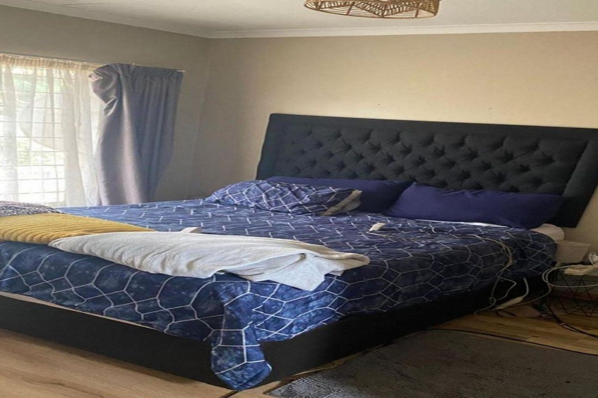 A bedroom featuring laminate flooring and neutral wall finishes, providing a comfortable and functional sleeping space.