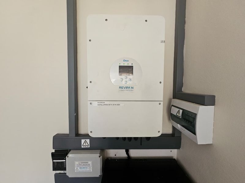 Wall-mounted solar inverter system with associated electrical distribution board and junction box, installed in 2023.