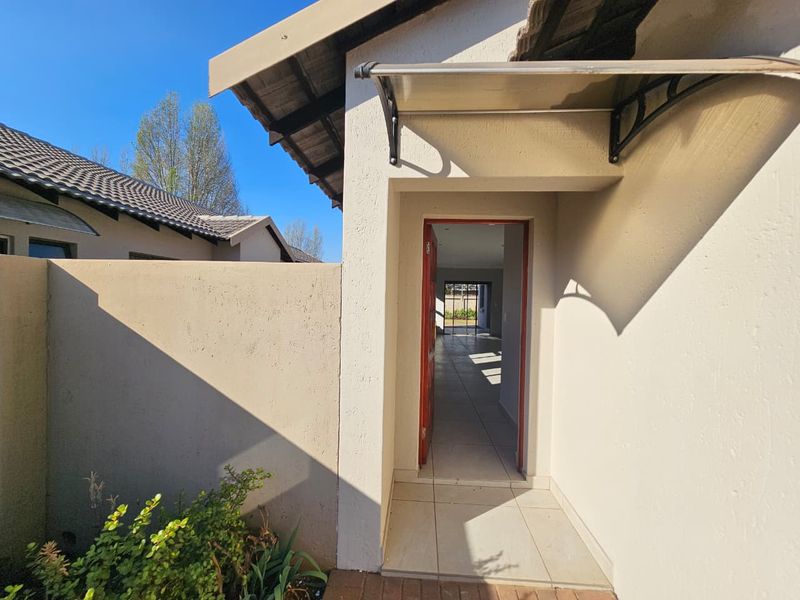 A clear view of the home entrance featuring a tiled porch, protective awning, and a direct line of sight into the interior living space.
