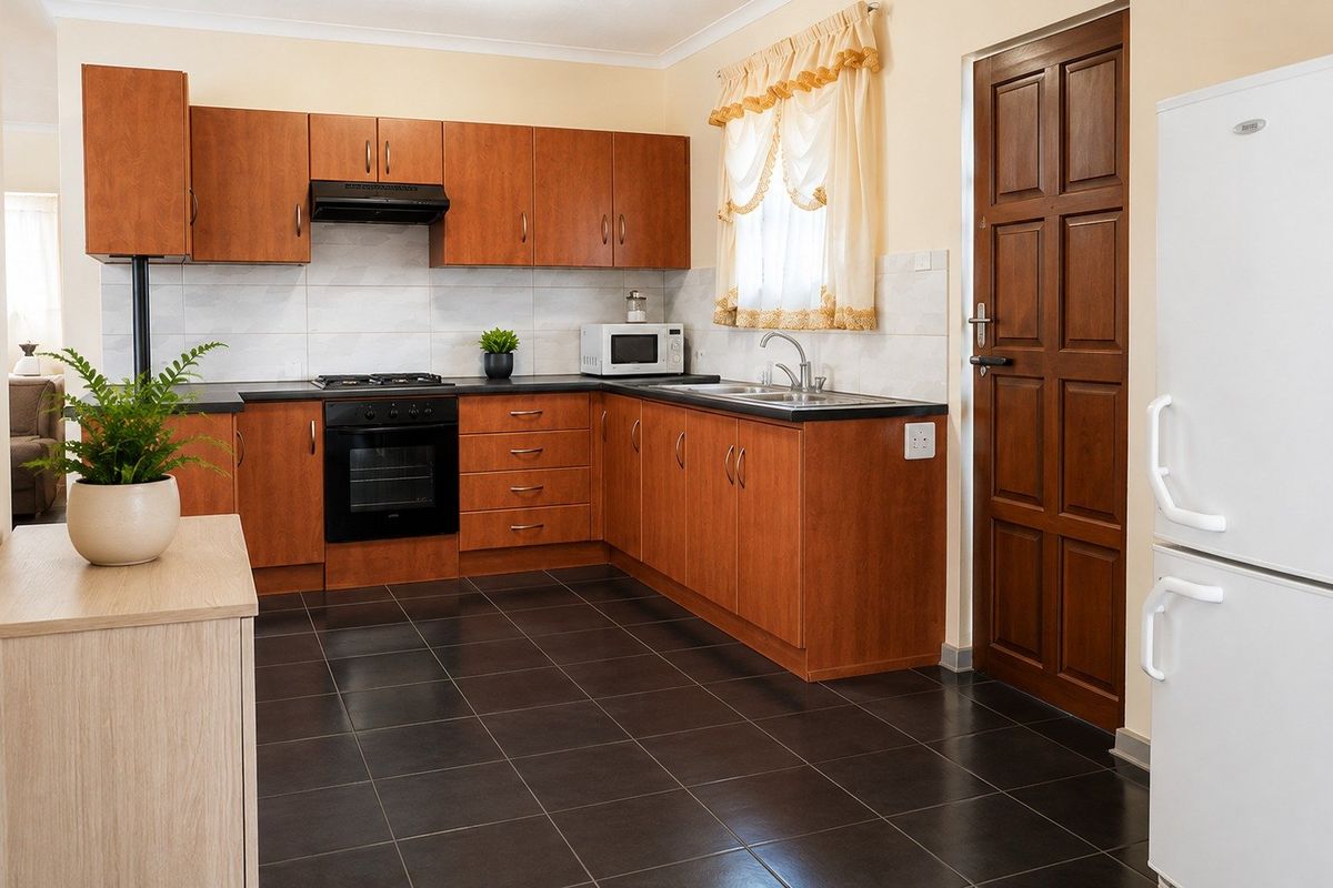 Functional kitchen featuring wood-finish cabinetry, built-in oven with gas hob, dark tiled flooring, and direct access to an exterior door.