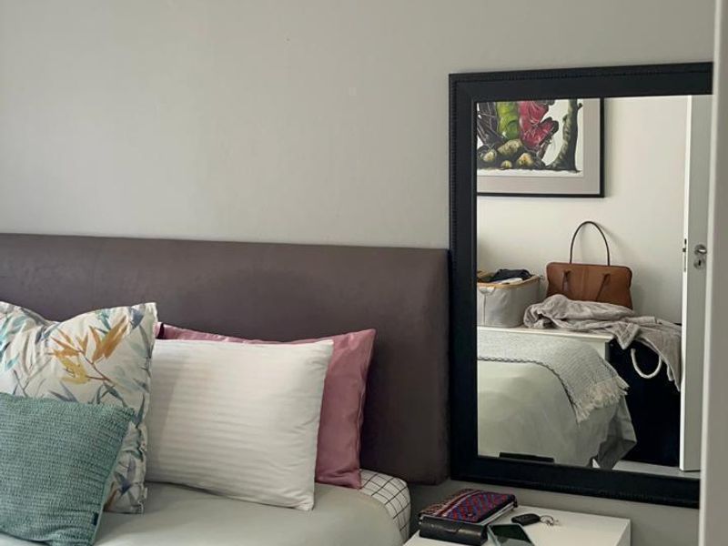 A well-maintained bedroom featuring neutral wall tones, tiled flooring, and clean architectural finishes, providing a comfortable and functional living space.