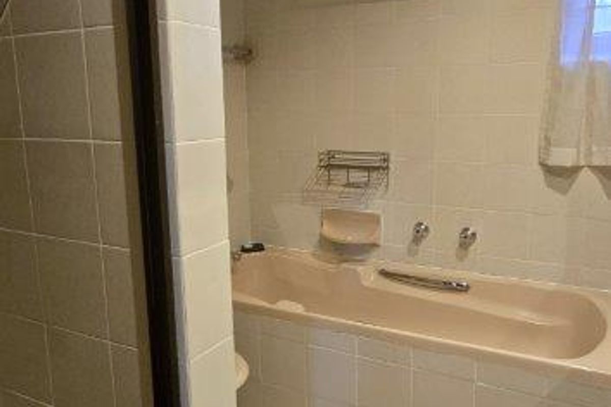 A dated bathroom featuring a built-in bathtub, separate shower enclosure, and neutral wall and floor tiling.