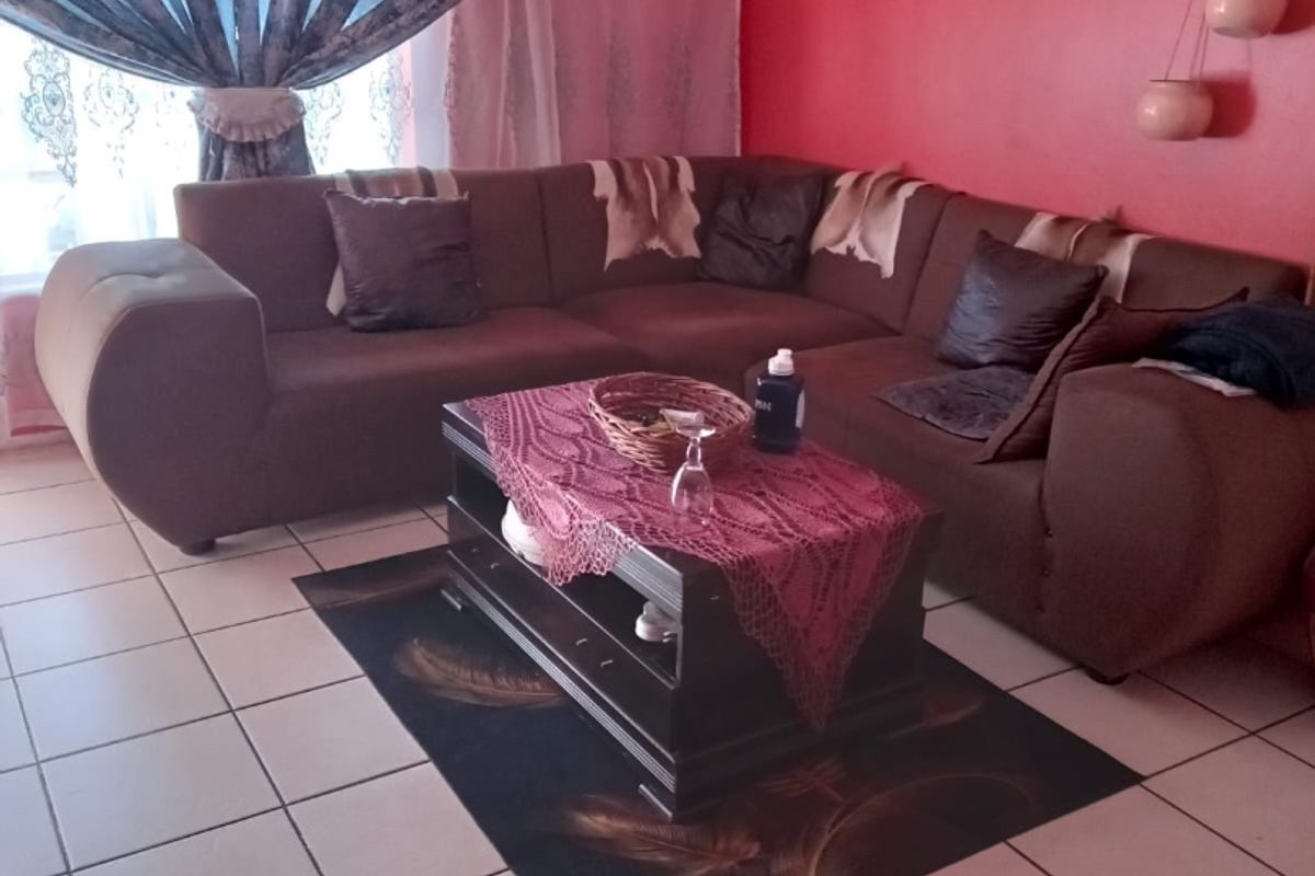 A living room area featuring ceramic floor tiles and window treatments.