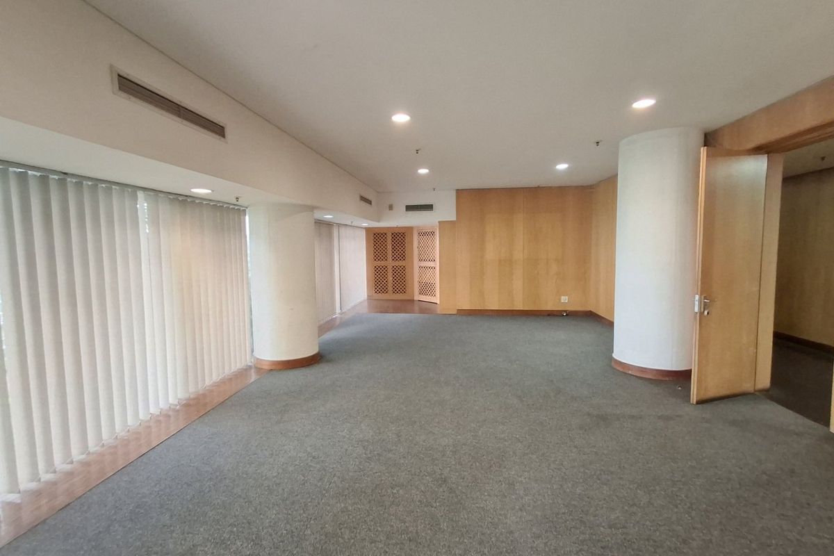 Spacious, empty commercial office area featuring timber veneer wall paneling, recessed lighting, ducted air conditioning, and large windows with vertical blinds.