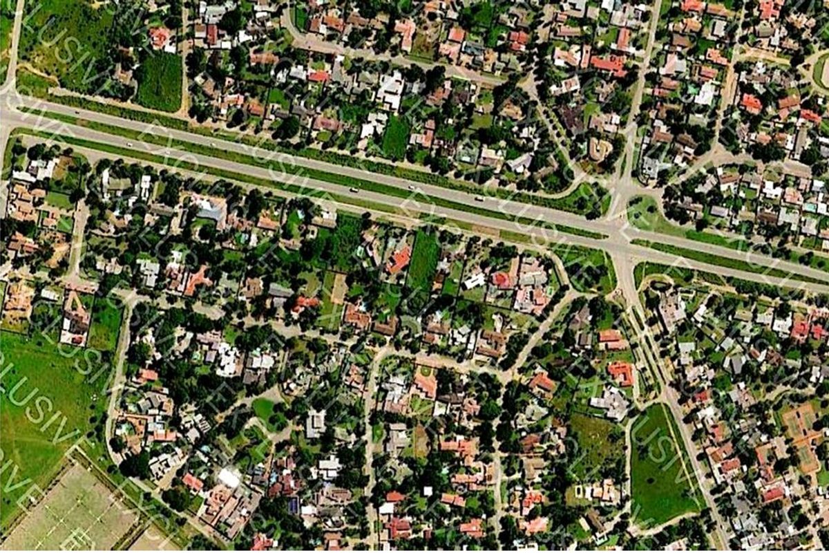 An aerial view of a residential neighborhood showing the layout of properties, streets, and surrounding infrastructure.