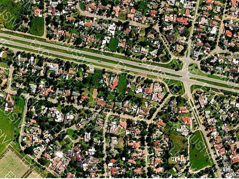 An aerial view of a residential neighborhood showing the layout of properties, streets, and surrounding infrastructure.
