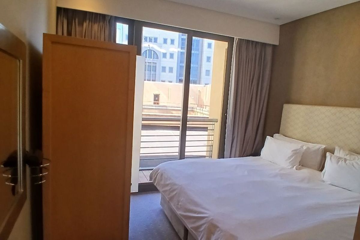 A bedroom featuring carpeted flooring, recessed lighting, and a sliding glass door providing access to a balcony.