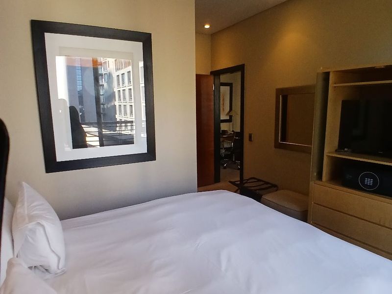 A well-maintained bedroom featuring recessed ceiling lighting, ducted air conditioning, and built-in cabinetry with an integrated safe.