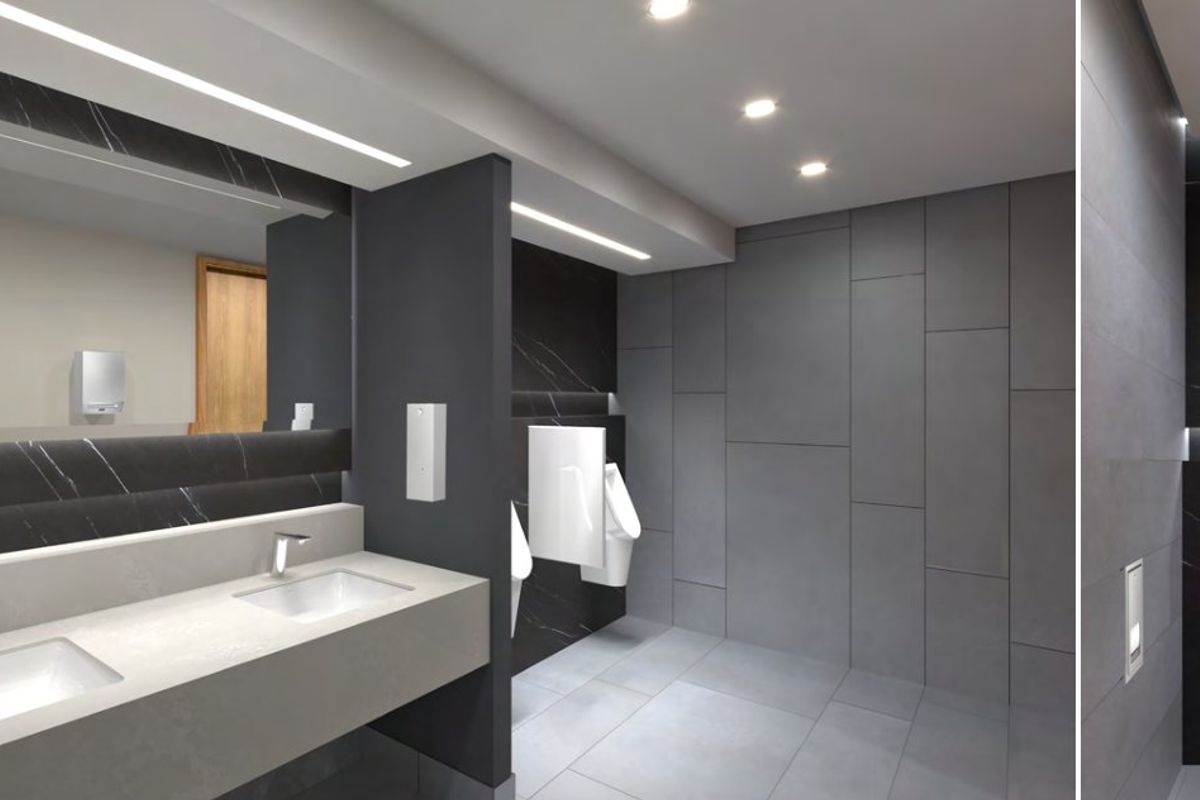 Modern commercial bathroom featuring a double vanity with integrated sinks, wall-hung toilet, urinals, and high-end dark marble-effect and grey tile finishes.