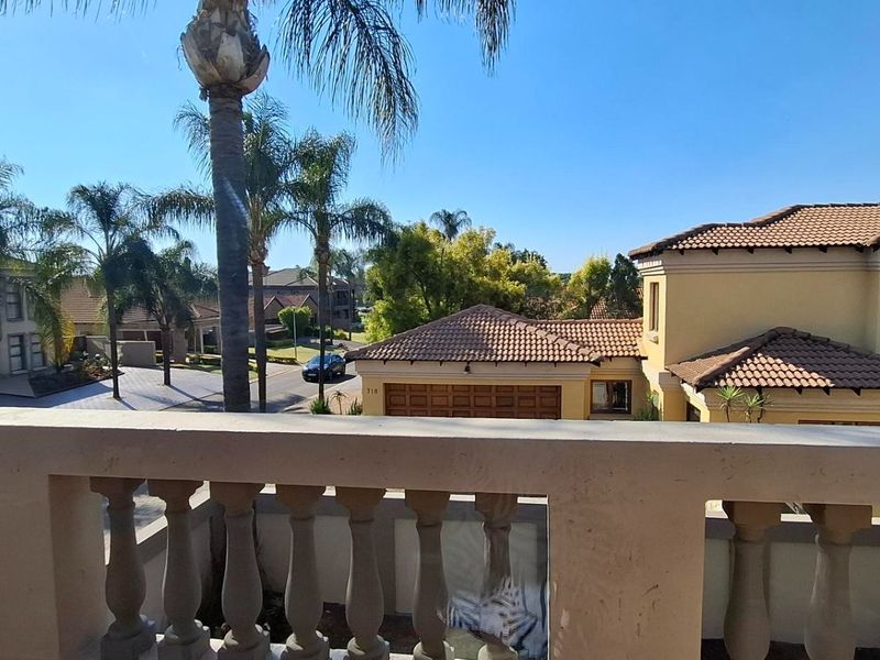 An elevated balcony featuring a classic balustrade, offering an open view of the surrounding residential neighborhood and streetscape.