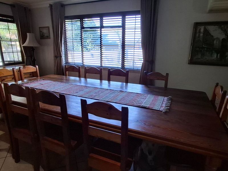 A dining room featuring tiled flooring, window blinds, and an integrated air conditioning unit.