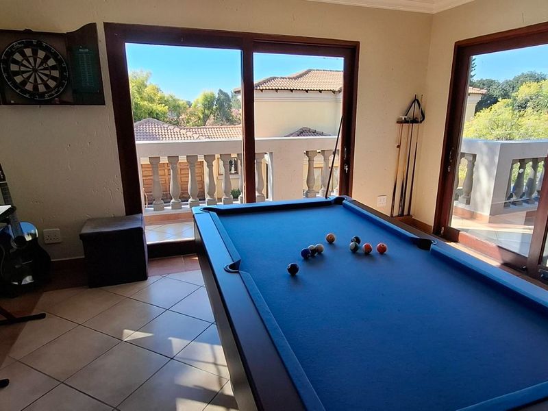 A spacious living area featuring tiled flooring and large sliding glass doors that open onto a balcony with a balustrade.