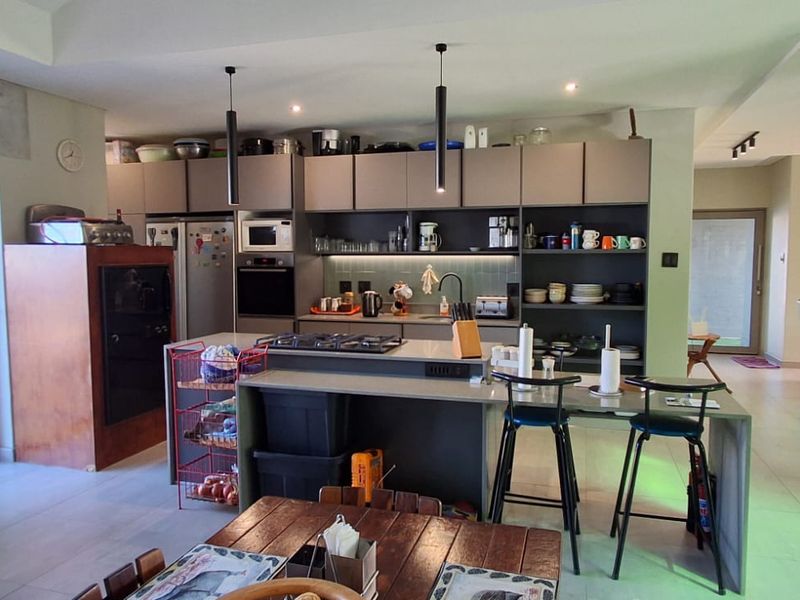 Spacious open-plan kitchen featuring a central island with gas hob, modern cabinetry, and seamless flow into the adjacent living area.