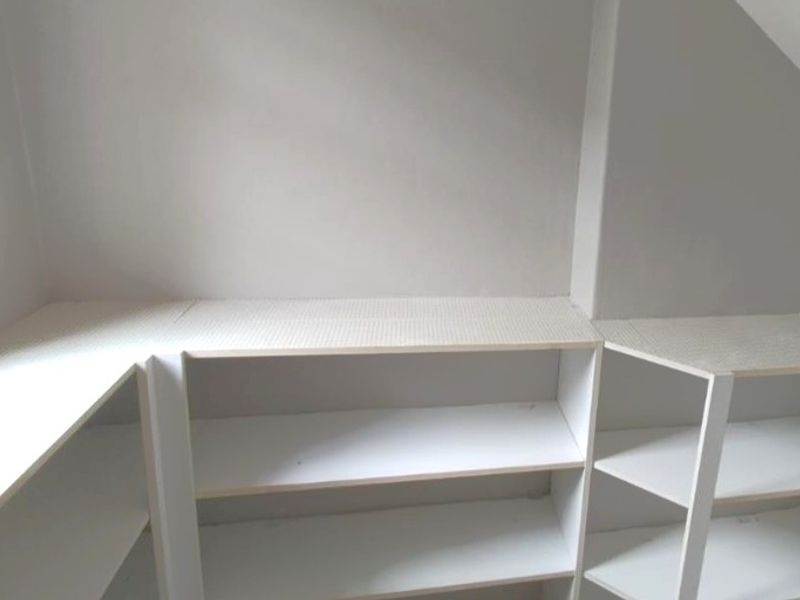 A functional storage area or pantry space featuring custom built-in white laminate shelving units.