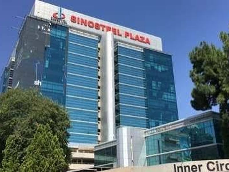 A modern multi-story commercial office building featuring a glass curtain wall facade and prominent signage.