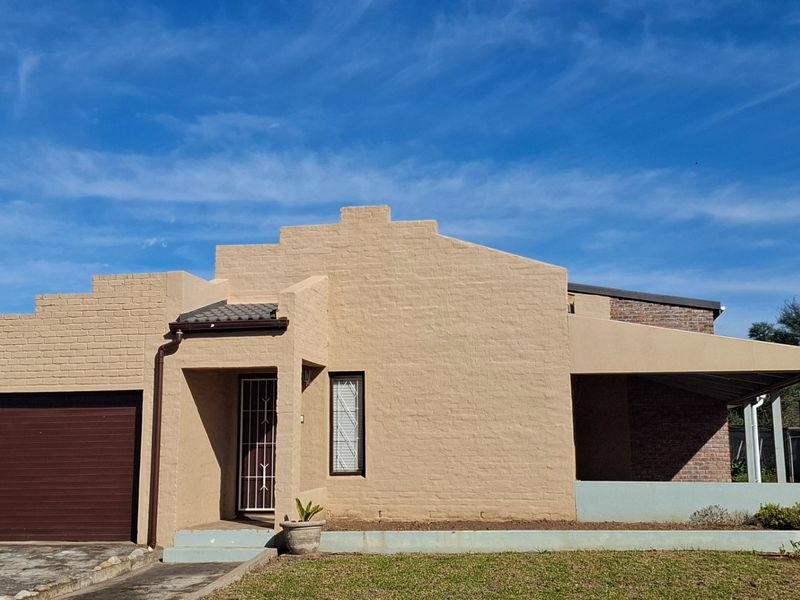 Front elevation of a single-story brick house featuring a garage, covered patio area, and secure gated entrance.