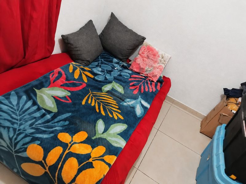 A compact bedroom space featuring tiled flooring and neutral wall finishes, suitable for a single bed setup.