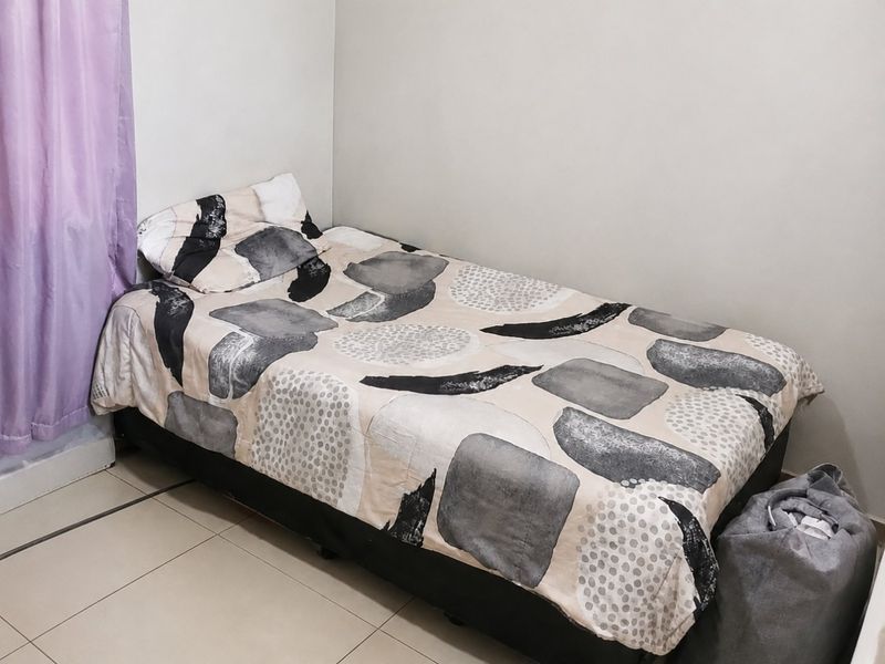 A simple bedroom featuring neutral wall finishes and tiled flooring, providing a functional space for rest.