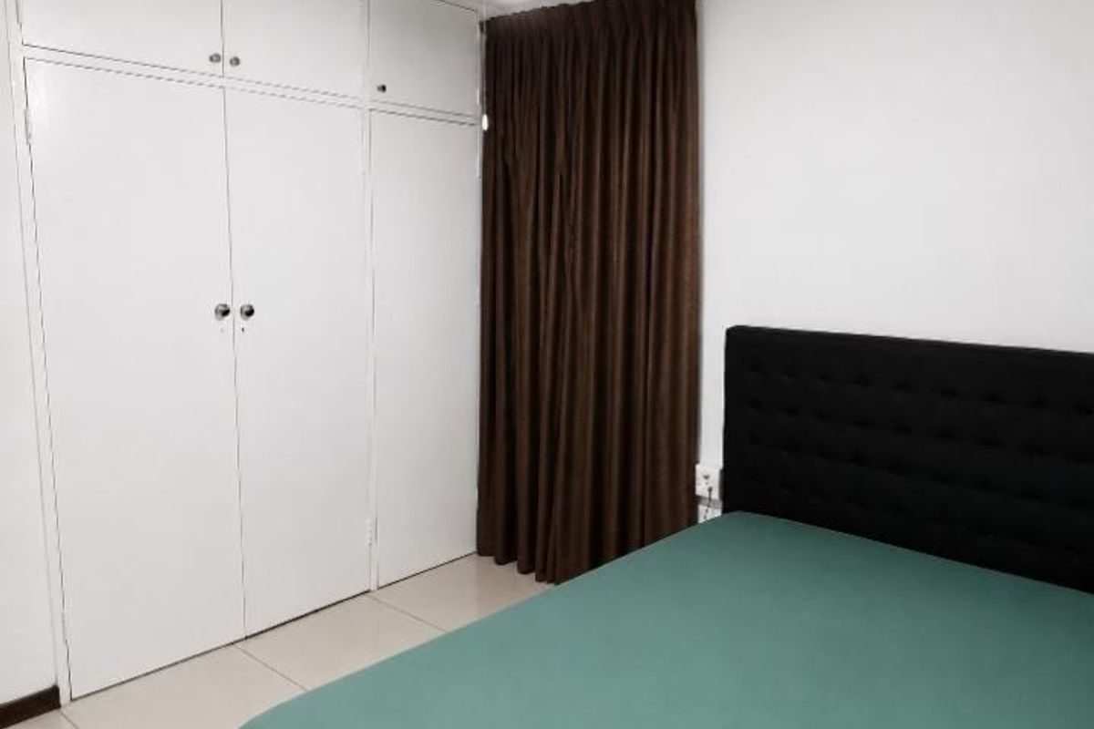 A bedroom featuring white built-in cupboards, tiled flooring, and neutral wall finishes.