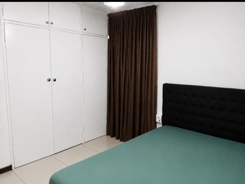 A bedroom featuring white built-in cupboards, tiled flooring, and neutral wall finishes.