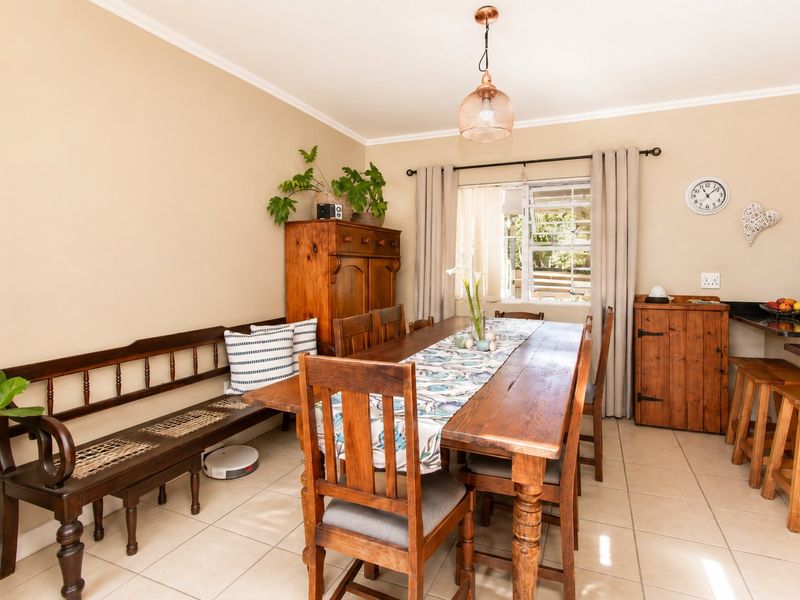 A dining area featuring tiled flooring, a pendant light, and a breakfast bar, providing a functional space for meals and casual seating.
