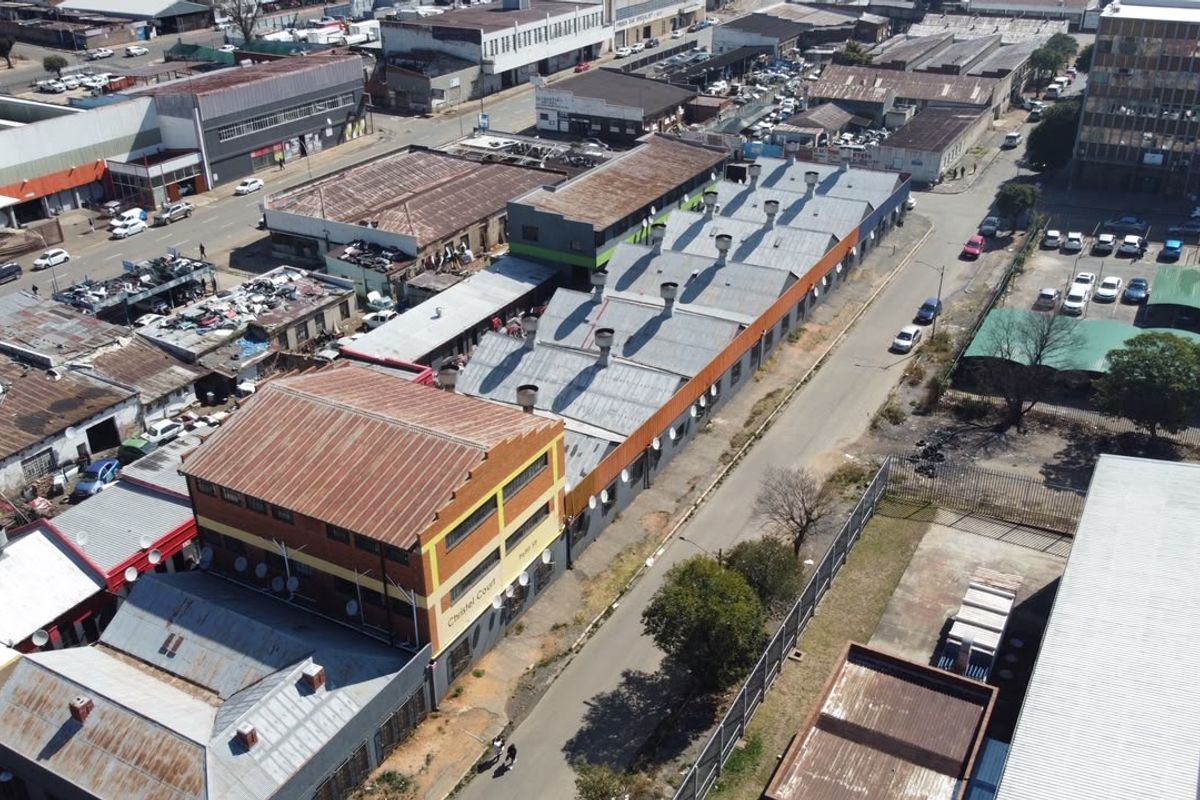 Aerial view of the apartment building complex showing the surrounding urban industrial area and roof structure.