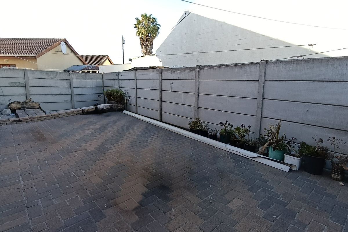 A paved rear courtyard area enclosed by precast concrete boundary walls, offering a low-maintenance outdoor space.