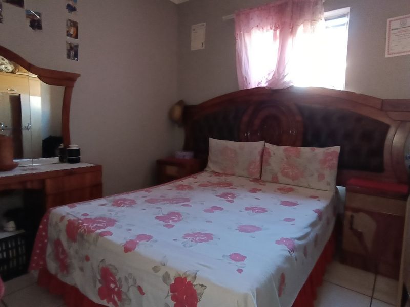 A bedroom featuring tiled flooring and a built-in cupboard, requiring cosmetic updates to improve the overall aesthetic and condition of the space.