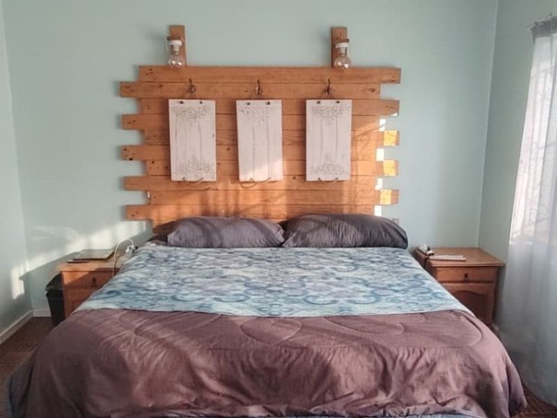 A bedroom featuring parquet flooring and a built-in closet, with natural light entering through the side window.