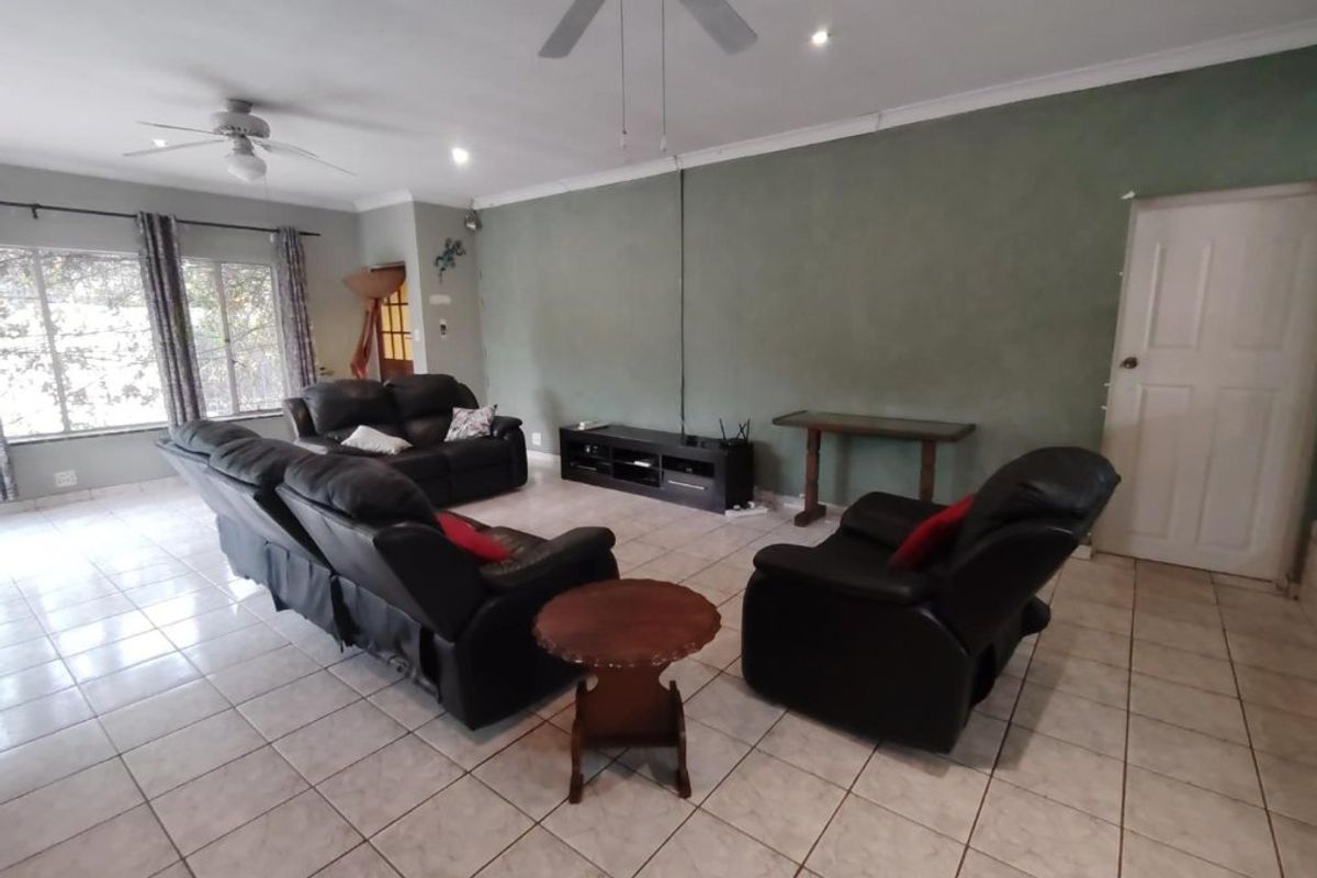 Spacious living room featuring tiled flooring, ceiling fans, and neutral wall finishes, offering a functional and comfortable layout for relaxation.