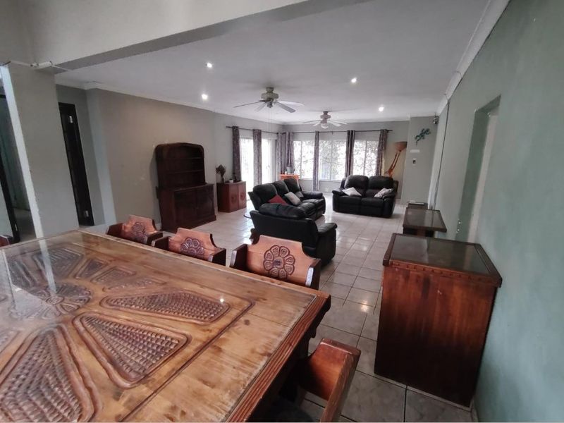 Spacious open-plan living and dining area featuring tiled flooring, recessed downlights, and ceiling fans, offering a versatile layout for family living.