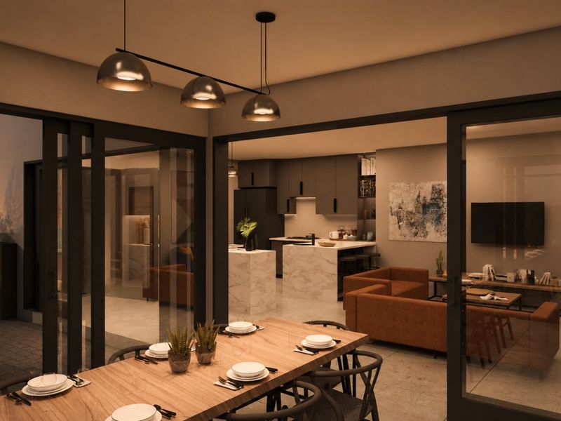 Modern open-plan living and kitchen area featuring a marble island, sleek cabinetry, and seamless indoor-outdoor flow through large sliding glass doors.