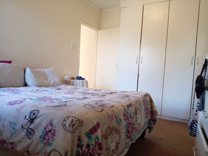 A functional bedroom featuring built-in cupboards and neutral wall finishes, providing a comfortable and practical living space.
