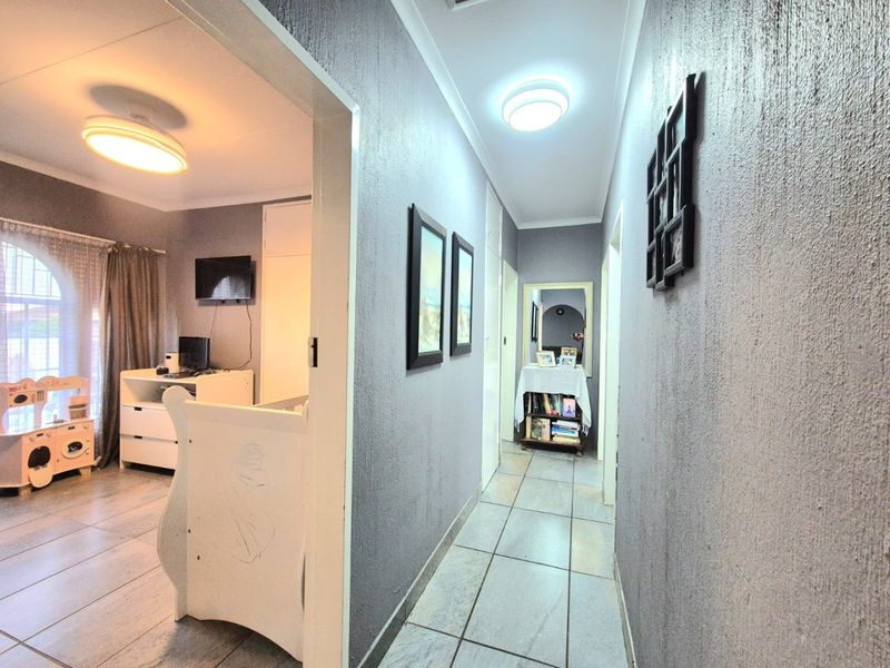 A functional hallway featuring tiled flooring and flush mount lighting, providing access to adjacent rooms within the townhouse.
