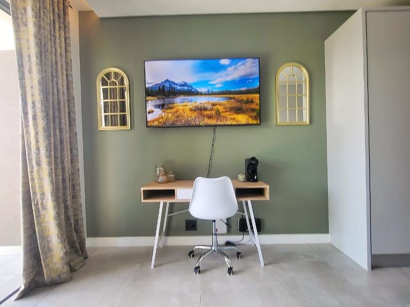 A well-maintained bedroom featuring neutral tiled flooring, a built-in wardrobe, and recessed ceiling lighting, creating a clean and functional living space.
