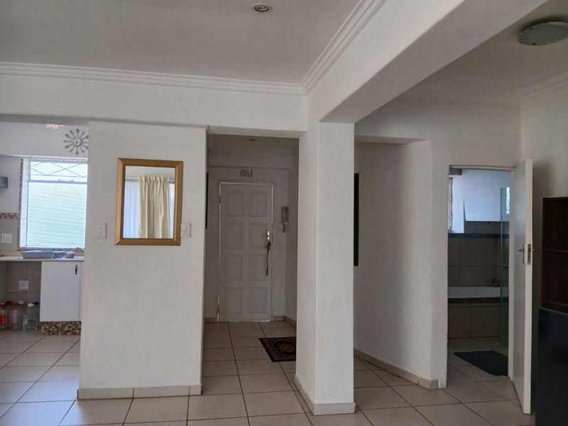 Open plan living area featuring tiled flooring, recessed lighting, and access to the kitchen, entrance, and bathroom.