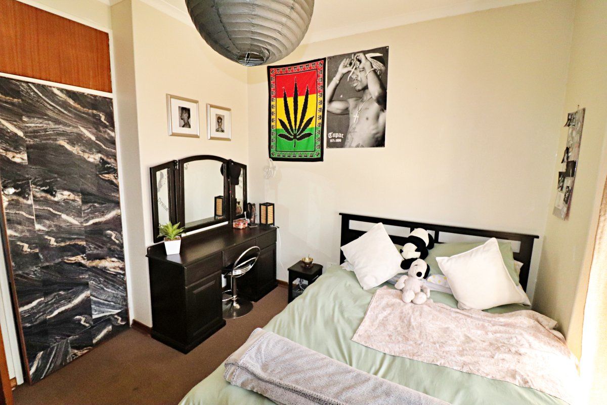 A bedroom featuring carpet flooring and a built-in wardrobe with a decorative finish.