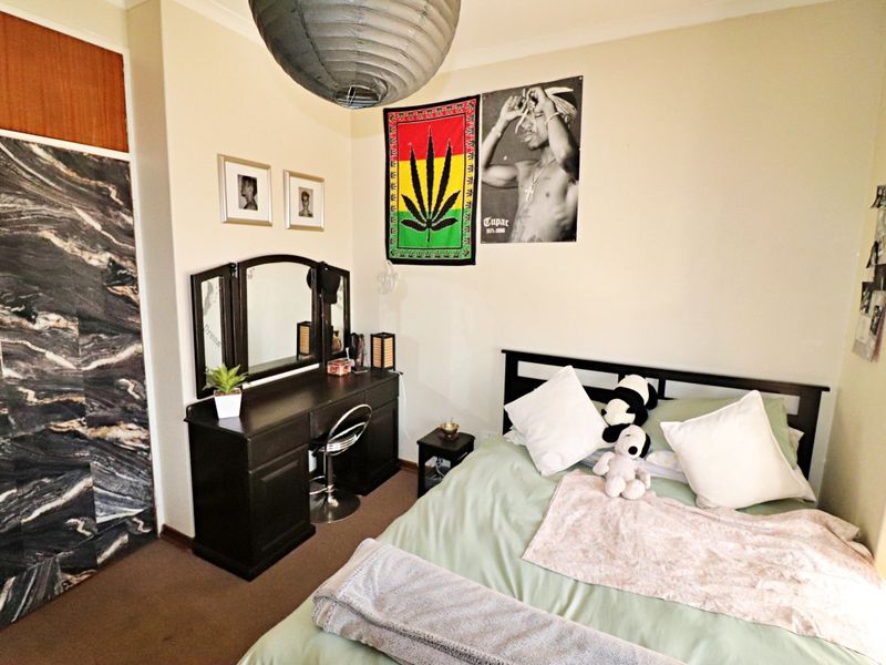 A bedroom featuring carpet flooring and a built-in wardrobe with a decorative finish.