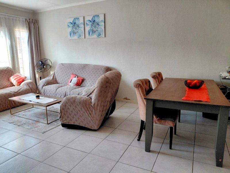 Open plan living and dining area featuring tiled flooring and access to an outdoor space via a sliding door.